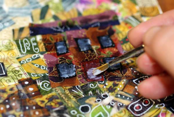 Adding gel medium on fabric surface. See instructions for creating fabric collages! By Peony and Parakeet.