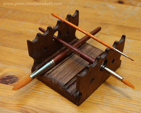 A wooden paint brush holder. Designed for wet brushes.