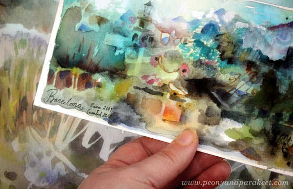 Holding a small watercolor painting.