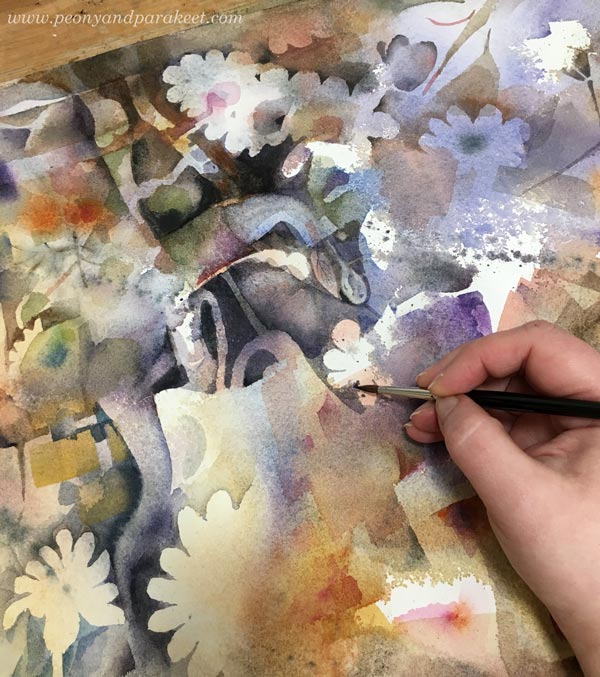 Adjusting details of a large floral watercolor painting.