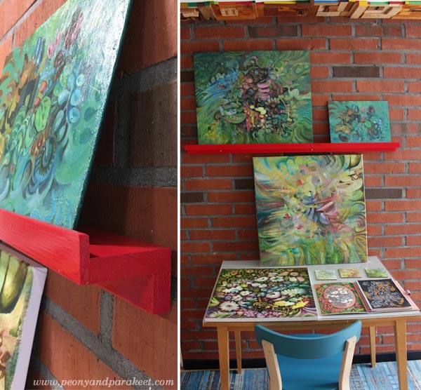 A hand made picture shelf for paintings and a small table for displaying art and art journals.