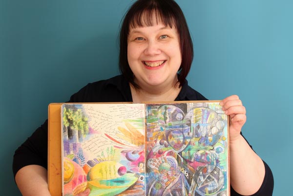 Artist Paivi Eerola holding one of her art journals.