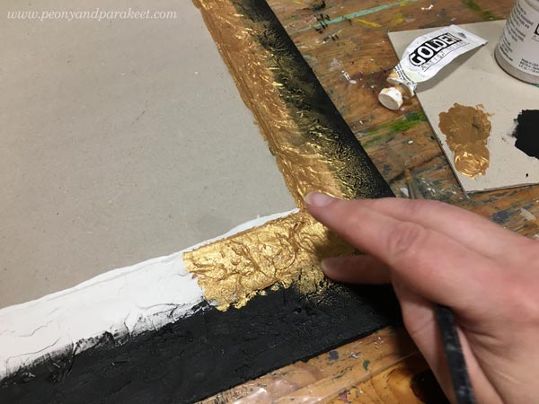 Painting a frame with gold and black acrylic paints.