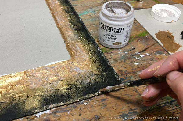 Adding gold mica flakes to a handmade frame.