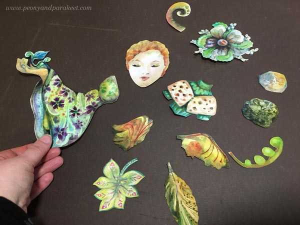 Arranging handpainted collage pieces.