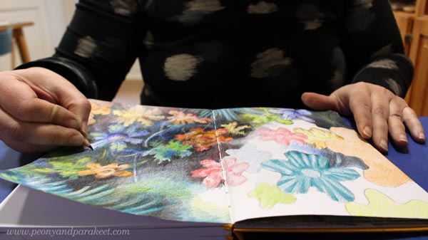 Coloring on an art journal. Joyful flowers in colored pencils.