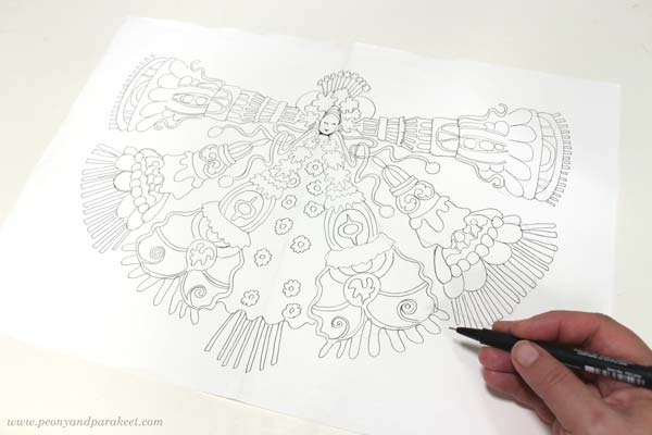 Drawing an ornament on marker paper. Ornamental figure with tassels.