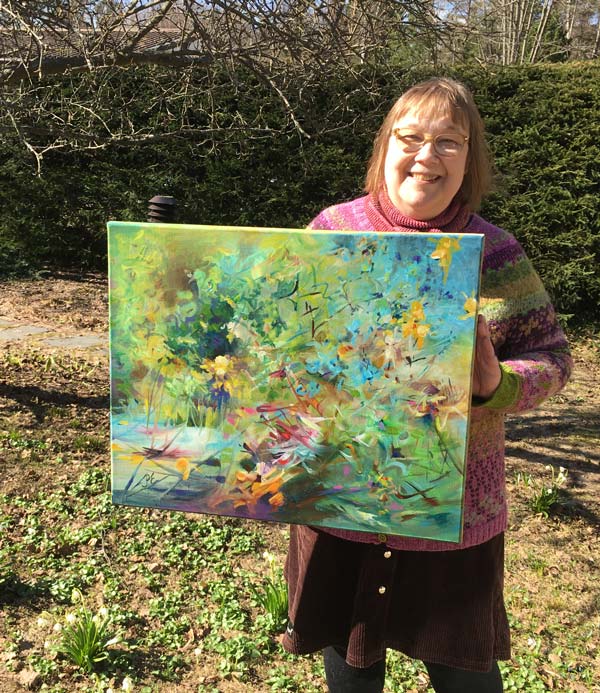 Holding a painting in the spring garden.