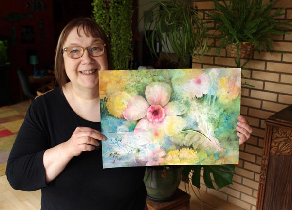 The Finnish artist Päivi Eerola holding her watercolor painting.