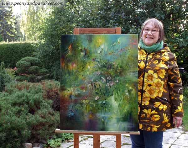 Finnish artist Päivi Eerola and her oil painting Elixir in the garden view.