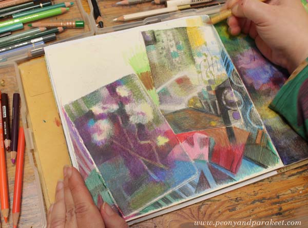 Coloring an art journal page with colored pencils.