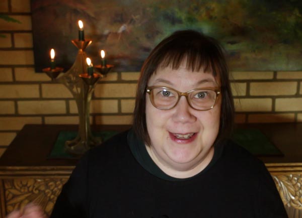 Paivi talking in the course Mystical Minis with four candles in the background.