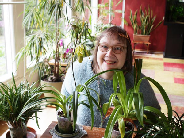 Paivi with house plants. Artist who loves plants and especially her orchids.