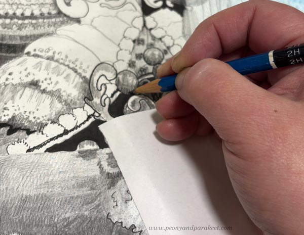 Using a piece of paper under the hand to protect a pencil drawing.